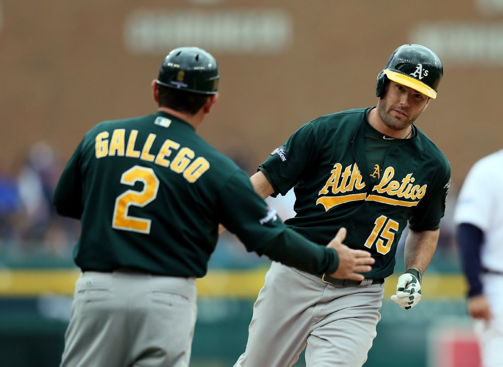 Oakland A's third-base coach Mike Gallego greets Seth Smith after the A's designated hitter homered in the fifth inning of Monday's game. (Rob Carr/Getty Images) 