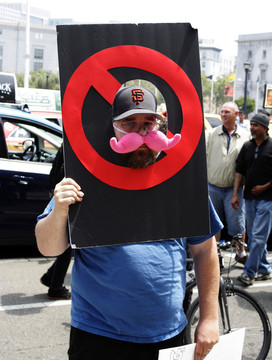 DeSoto Cab Company driver Corey Lamb protests against app-based ride-service companies outside San Francisco City Hall. (Alex Enslie/KQED)