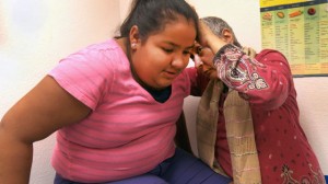 Dr. Razia Sheikh, a Fresno pediatrician, examines 12-year-old Veronica Regalado, who is struggling with a weight problem. (Joel Pickford/Center for Investigative Reporting)