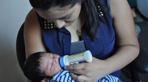Carretero feeds her infant son. (Marci Lopez/The kNOw at New American Media)