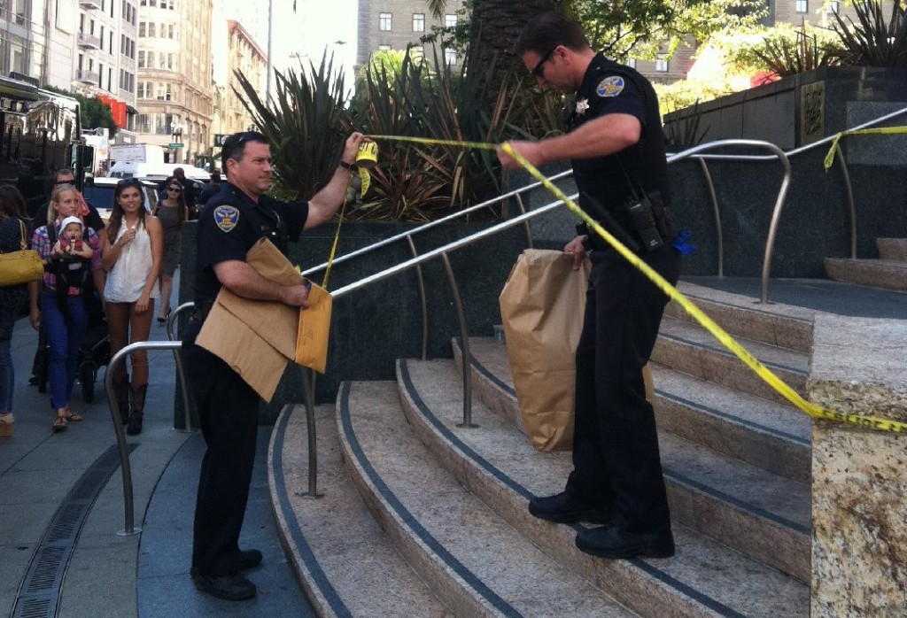 Police officers remove a suspicious package that led to the evacuation of San Francisco's Union Square at midday. (Rachael Marcus/KQED) 