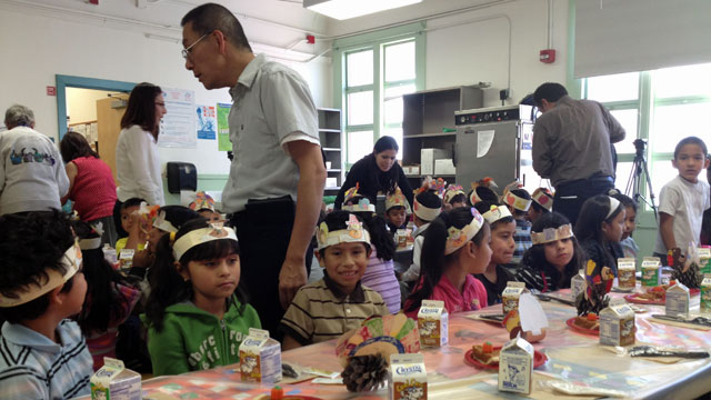 First grade teacher Mario Chang tries to keep his students quiet as they wait for the rest of the school to assemble for a Thanksgiving meal.