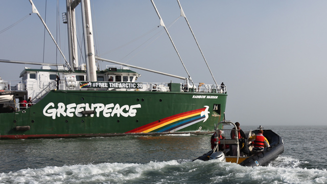 Greenpeace members motor out in a small boat to greet the Rainbow Warrior III as it enters a foggy San Francisco Bay on Friday. (Deborah Svoboda/KQED)