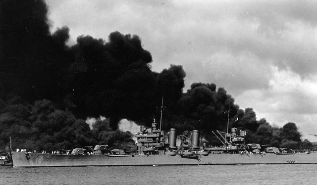 The USS Phoenix steams past battleships burning after attack on Pearl Harbor. (U.S. Naval Historical Center)