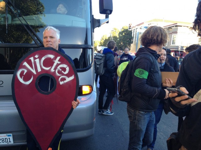 Anti-eviction protesters block a Silicon Valley bus -- this one carrying Apple employees -- at 24th and Valencia streets in San Francisco's Mission District (Vinnee Tong/KQED)