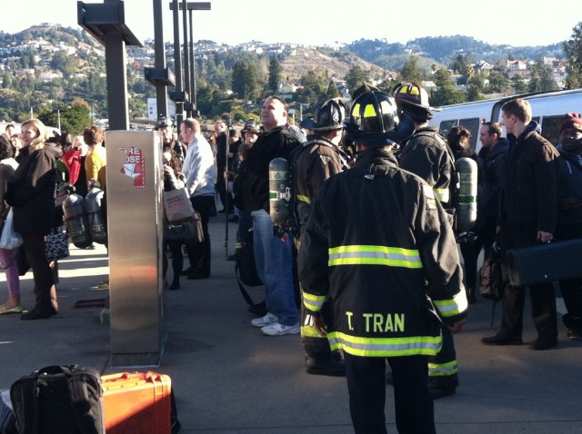 Oakland firefighters and passengers from stricken BART train mingle on platform at Rockridge Station. (Scott Bloom). 