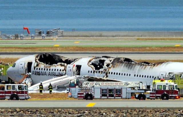 Fire trucks surround an Asiana Airlines Boeing 777 on the runway at San Francisco International Airport after it crashed last July. (Josh Edelson/AFP/Getty Images)