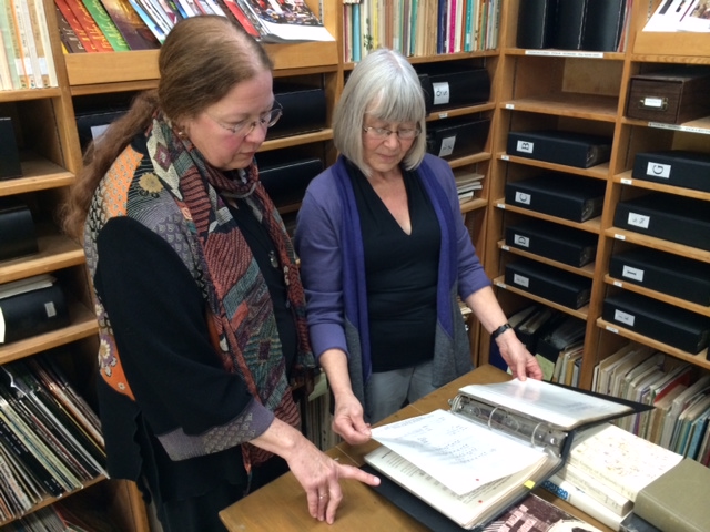 Holy Names University Music Lecturer Gail Needleman (left) and Kodály Center Director Anne Lasky pore over the printed originals of some of the folk songs now on the Center's digital archive. (Joshua Johnson/KQED)
