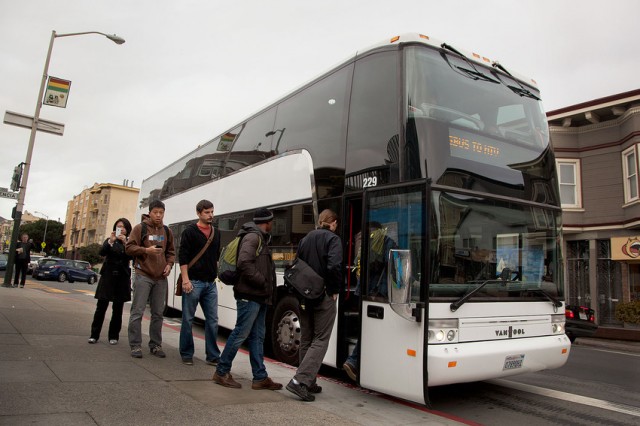 Workers board a private bus at 24th and Valencia streets. (Mark Andrew Boyer/KQED)