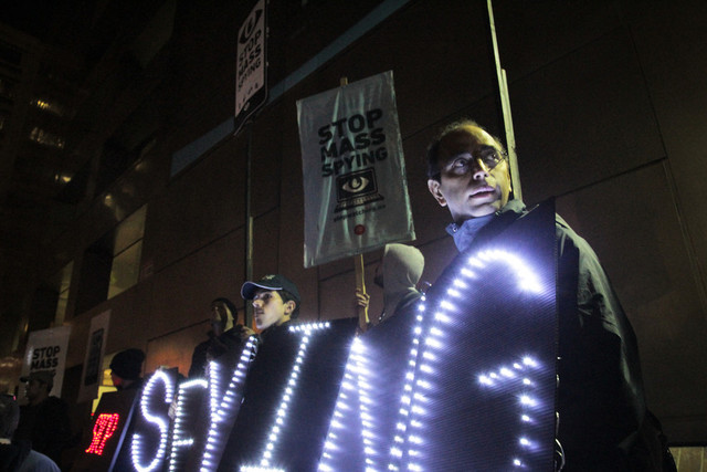 At Tuesday's anti-surveillance protest, the Bay Area Light Brigade held signs reading "stop spying" and "revolt." (Jeremy Raff/KQED)