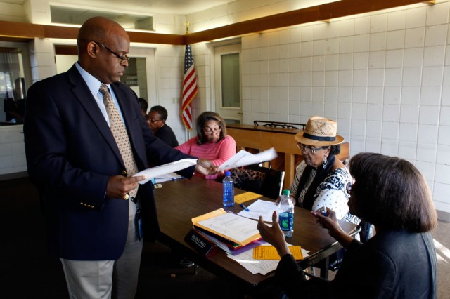 Richmond Housing Authority Executive Director Tim Jones hands out copies of notes from a previous meeting to residential council leaders from the city’s public housing properties. Jones blames years of federal funding cuts for the problems plaguing the authority. (Lacy Atkins/San Francisco Chronicle)
