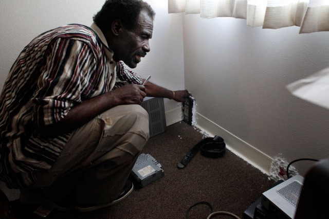 Eddie Williams, 62,  glues items such as video cassettes to his walls to stop mice from getting into his Nevin Plaza apartment. Williams, whose rent is $251 a month, asked the Richmond Housing Authority to fix the problem, but he says nothing happened.(Lacy Atkins/San Francisco Chronicle)