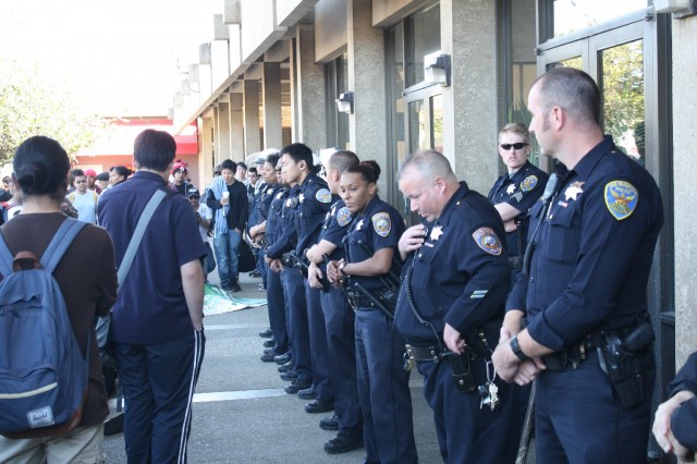 Police from the San Francisco and City College campus police departments block the majority of protesters from entering Conlan Hall after a rally calling for the resignation of special trustee Robert Agrella on March 13, 2014. (Alex Emslie/KQED)