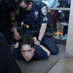 City College student Otto Pippenger is detained by SFPD officers outside an administration building. (Alex Emslie/KQED)