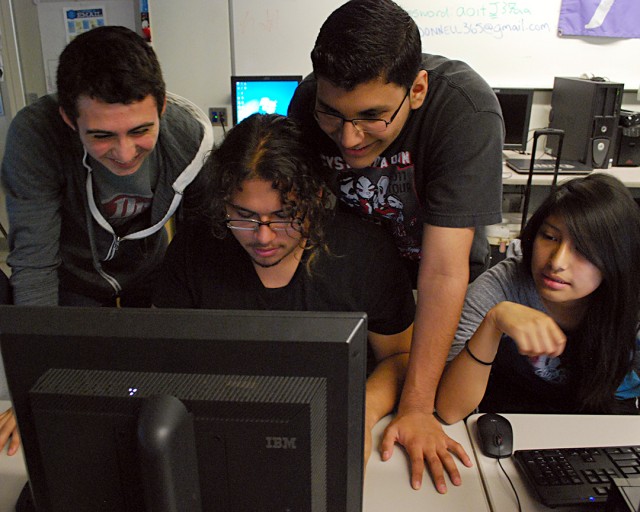 Joe Sanbria (seated) gets help from his classmates with the programming language Python at Foshay Technology Academy in Los Angeles. (Lillian Mongeau,/EdSource Today)