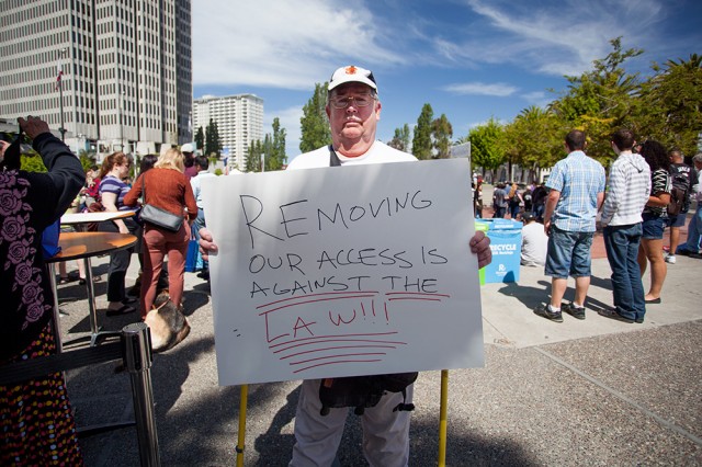 Bob Planthold attended the unveiling to protest the new cars' perceived lack of accessibility (Mark Andrew Boyer/KQED)