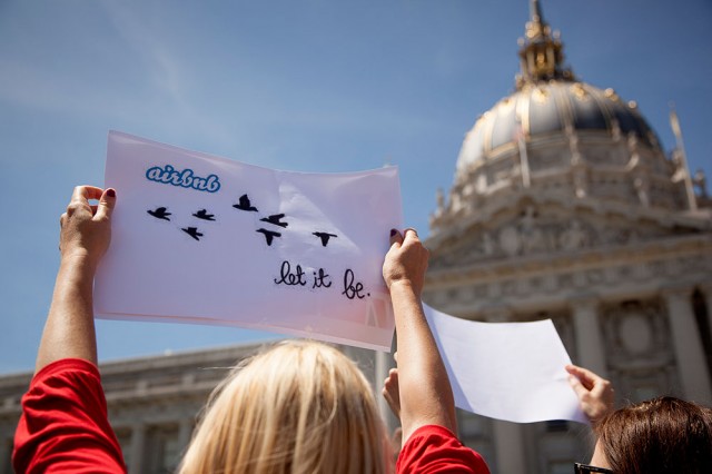 Protestors display signs supporting Airbnb at a rally for short-term rentals in front of San Francisco City Hall (Mark Andrew Boyer/KQED)