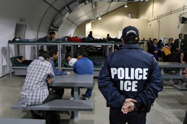 An Immigration and Customs Enforcement officer guards a group of 116 Salvadorean immigrants that wait to be deported,at Willacy Detention facility in Raymondville, Texas. (Jose Cabeza/AFP/Getty Images)