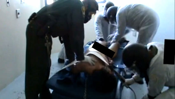 A still image from a video showing California prison guards dousing mentally ill inmates repeatedly with pepper spray.