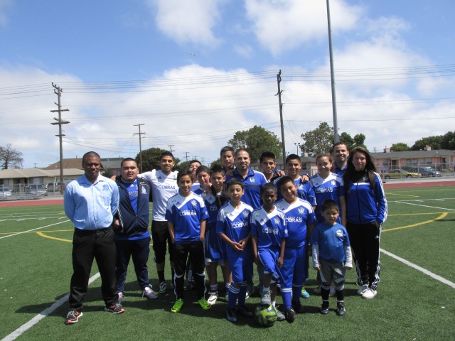 President of the Richmond Sol Soccer League Diego Garcia in the middle with a mix of players from the recreational and competitive teams. (Cristina Matamoros/KQED)