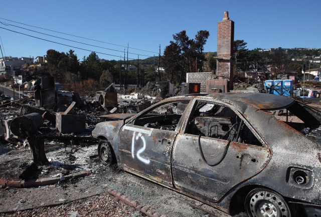 The shell of a car sits in the driveway of a burned home near the epicenter of the gas line explosion that devastated San Bruno. (Justin Sullivan/Getty Images)