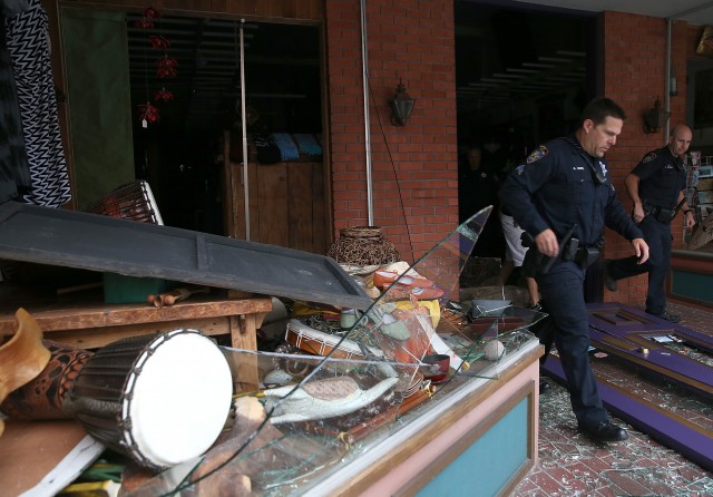 Police officers exit a damaged building. (Justin Sullivan/Getty Images)