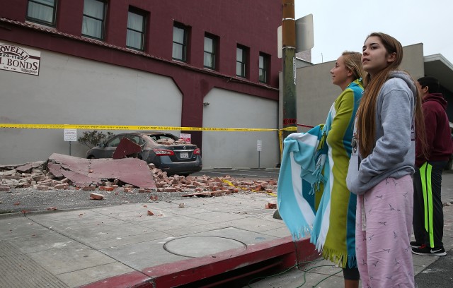 People survey a damaged car. (Justin Sullivan/Getty Images)