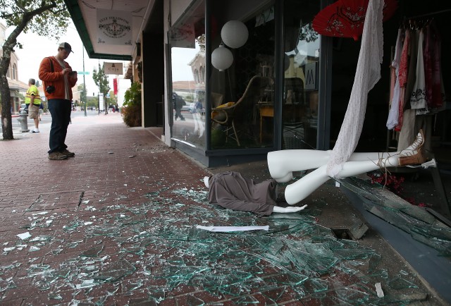 A mannequin lies in broken glass in front of a damaged building. (Justin Sullivan/Getty Images)