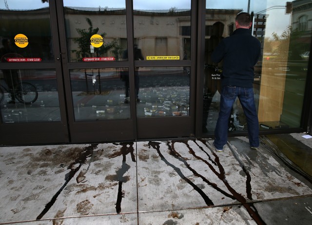  Vinegar flows out of the front door of a business damaged by the earthquake. (Justin Sullivan/Getty Images)