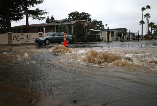 Water gushes from a water main break outside of a mobile home park. (Justin Sullivan/Getty Images)