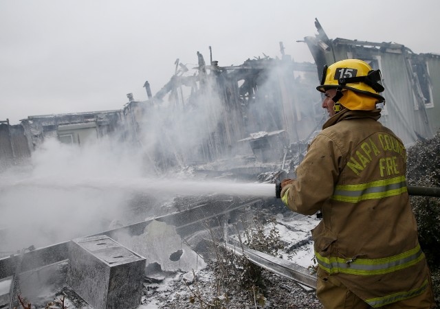 A Napa County firefighter sprays foam on hot spots from a fire at a mobile home park. (Justin Sullivan/Getty Images)