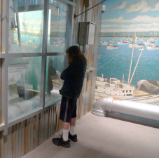 Eleven-year-old Jonathan Nerenberg peers into a seaside diorama based on his favorite Steinbeck novel, "Cannery Row." (Rowan Moore Gerety/KQED)