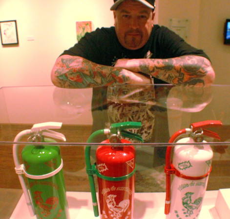 The artist known as Sket One with his Sriracha-inspired "Sketinguishers" at the "L.A. Heat" exhibit in Los Angeles. (Steven Cuevas/KQED)