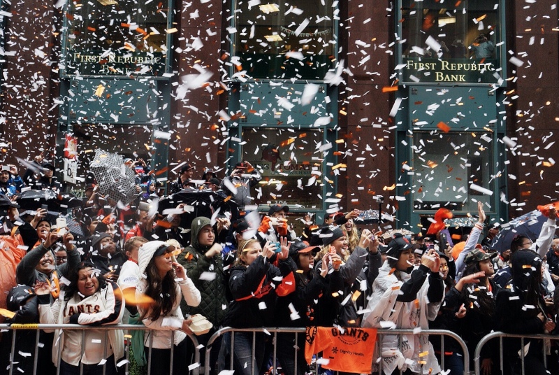 Confetti and rain pour down on fans along Market Street. (James Tensuan/KQED)
