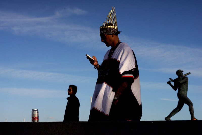 Peter Regaldo checks his phone outside of AT&T Park prior to Game Three of the World Series. (James Tensuan/KQED) 