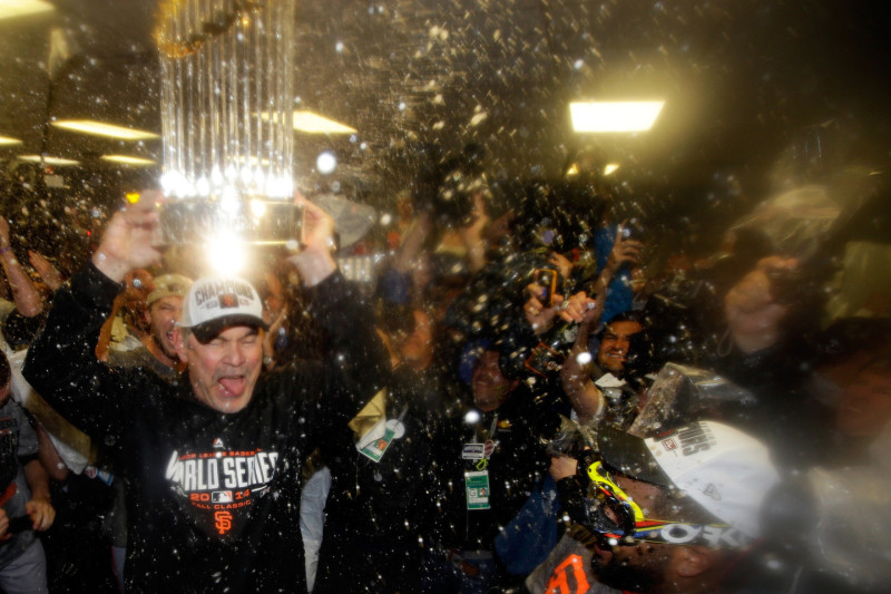 Bruce Bochy #15 of the San Francisco Giants celebrates with The Commissioner's Trophy in the locker room after a 3-2 win over the Kansas City Royals. (Ezra Shaw/Getty Images)