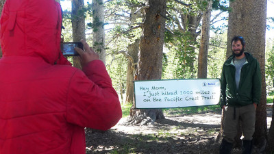Magnuski brings a sign for hikers to take their photos next to, marking the first 1,000 miles of the PCT. (Lisa Morehouse/KQED)