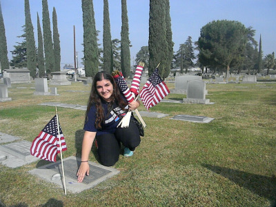Marina Chardukian and other volunteers put flags out for Veteran's Day. (Alice Daniel/KQED) 