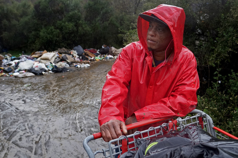 Mike Cooper takes a break from pushing his shopping cart of belongings out of The Jungle. He's been living in the Jungle for about six months after falling on bad luck when he moved to San Jose from St. Louis. (James Tensuan/KQED)