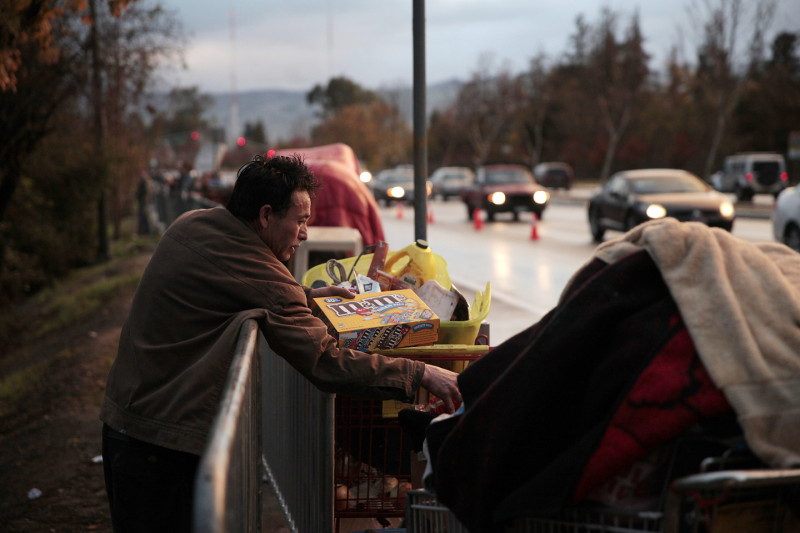 Residents dragged their belongings to the side of the road. Some had friends to pick them up. Others left on foot. (James Tensuan/KQED)