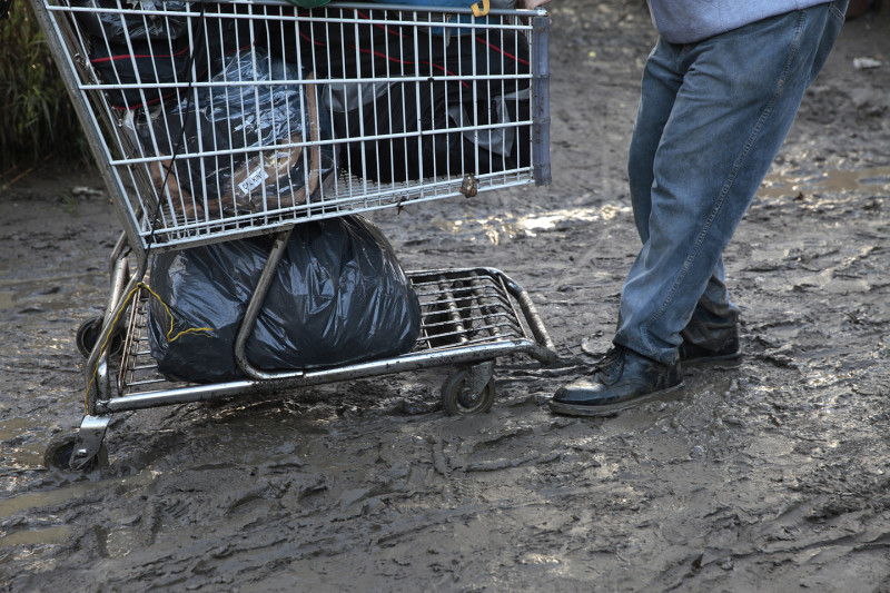The rain and mud made the move messy. At one point a dump truck brought in to cart debris away got stuck in the muck. (James Tensuan/KQED)