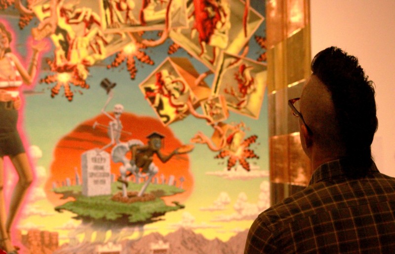 A visitor gets a closer look of a Robert Williams painting on view at the LA. Municipal Art Gallery 