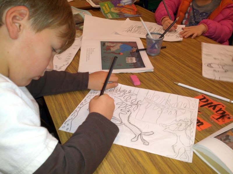 A first grader at Peralta Elementary works on a pencil drawing.