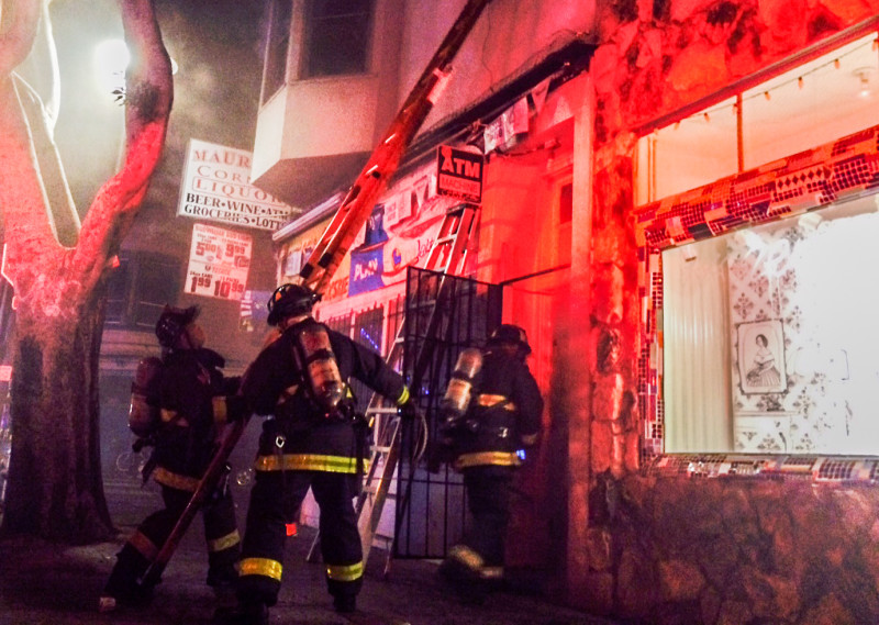 Firefighters responding to March 11, 2015 blaze that killed two members of a family living in a second-floor apartment at 24th Street and Treat Avenue in San Francisco's Mission District. 