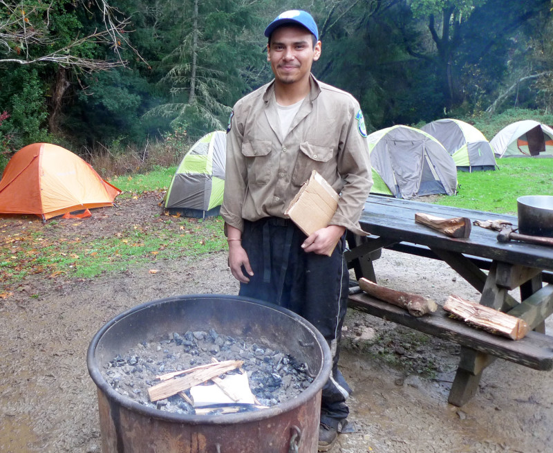 Gabino Lopez tends the fire, also known as the camp TV.