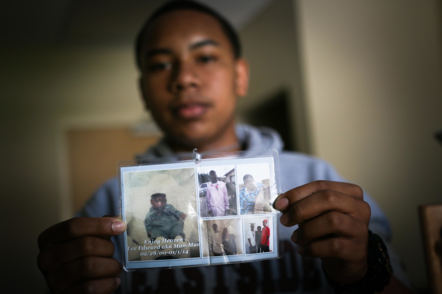 Diamond Allen shows off pictures of his friend, Lee Weathersby III, who was shot and killed in Oakland. (Jeremy Raff/KQED)