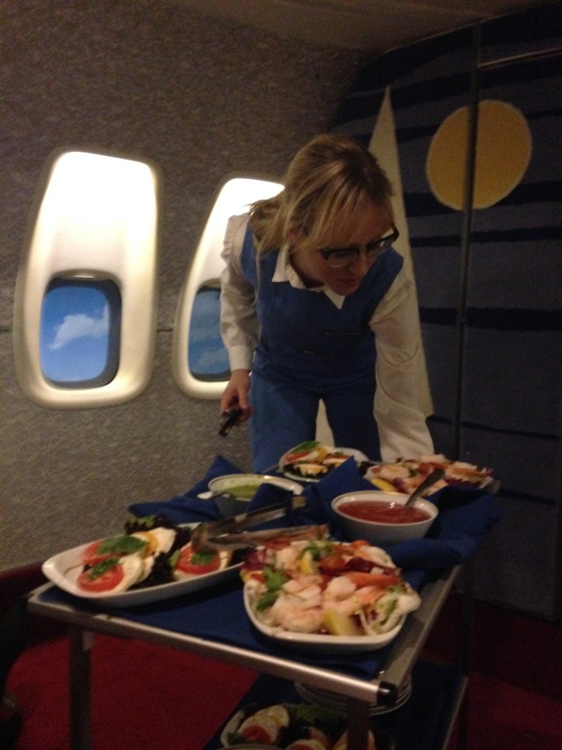 Betsy Holt serves up shrimp salad and other appetizers aboard the Pan Am Experience.