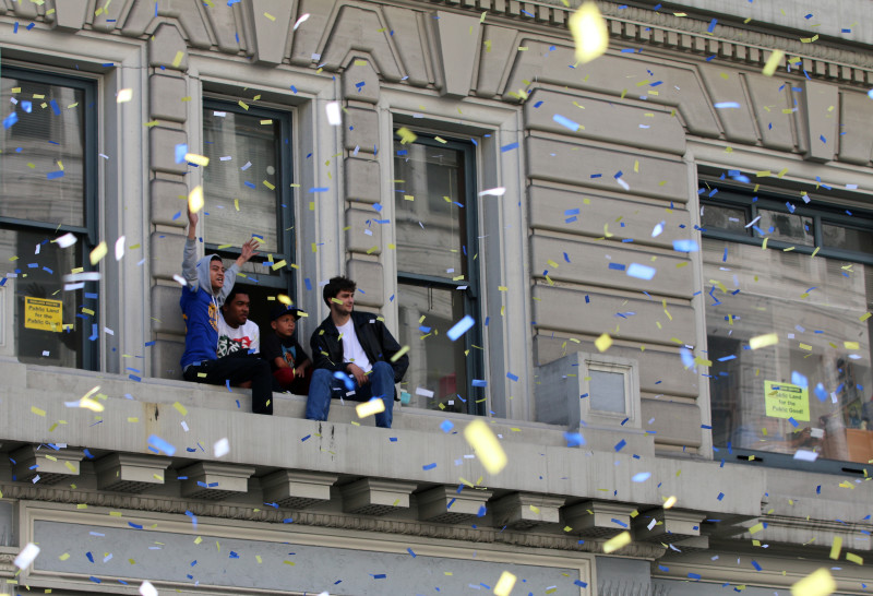 Fans look out at the Warriors parade as it moves down Broadway. (Adam Grossberg/KQED)