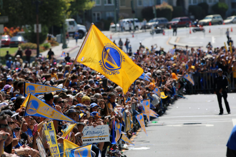 Fans on Grand Avenue cheer as Steph Curry passes by. (Adam Grossberg/KQED).