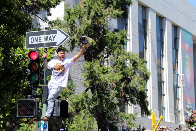 Excited fans packed the streets and climbed on lamp posts and street lights. (Adam Grossberg/KQED)